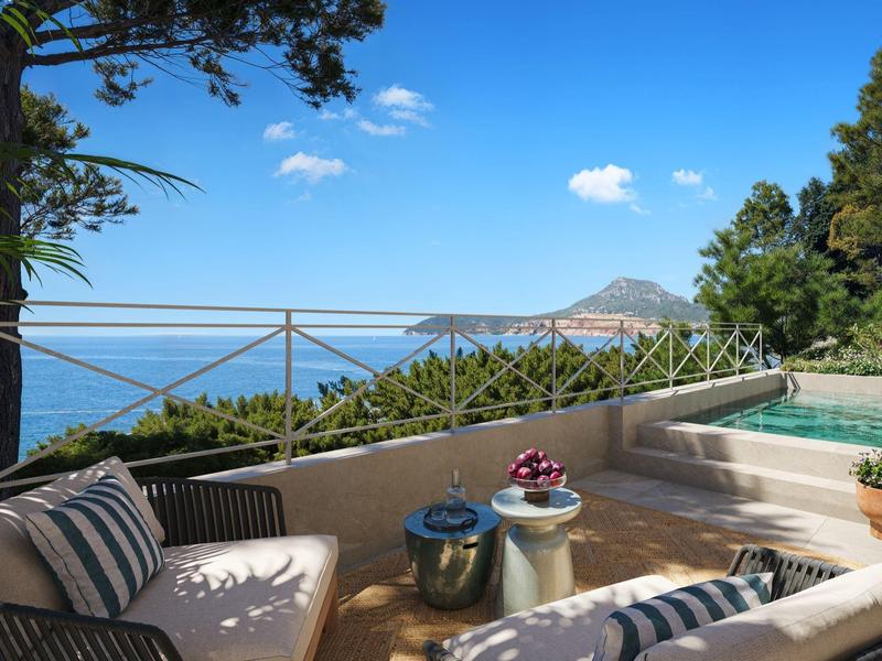 Terrasse mit gemütlichen Sitzgelegenheiten, Pool und Blick auf das Meer und Berge.