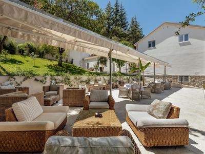 Mobili lounge accoglienti sotto una tenda parasole nell'area esterna di un hotel.