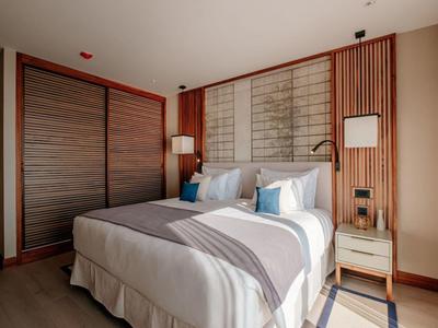 Modernes Hotelzimmer mit Doppelbett, Holzvertäfelung und sanfter Beleuchtung