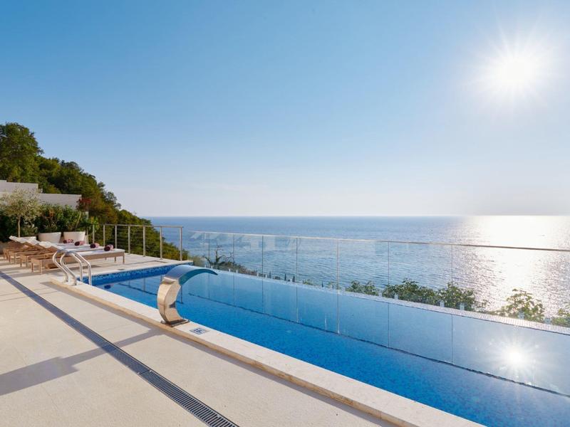 Infinity-Pool mit Meerblick und Sonnenlicht an einem klaren Tag