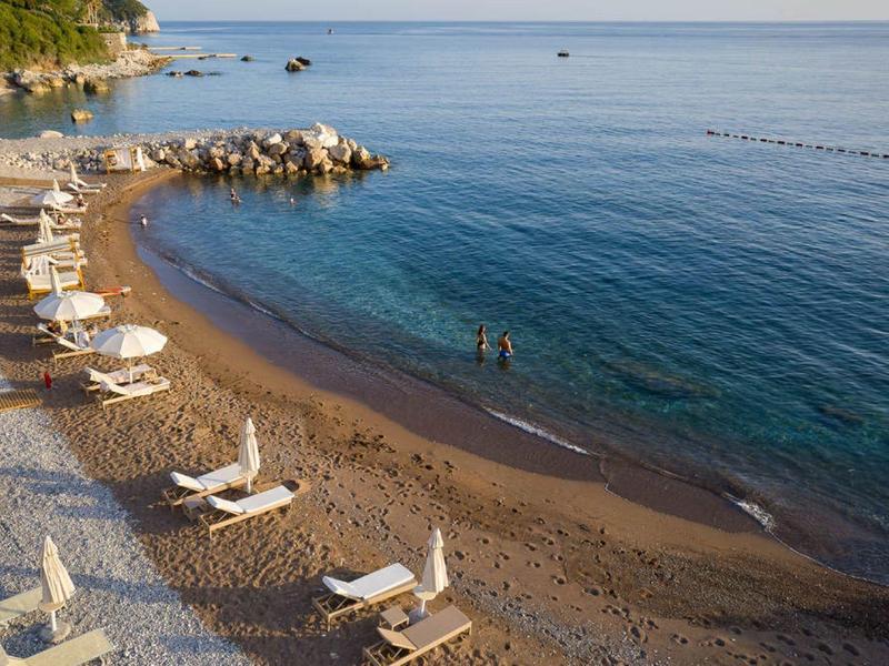 Strand mit Sonnenliegen und ruhigem Meer an einem sonnigen Tag