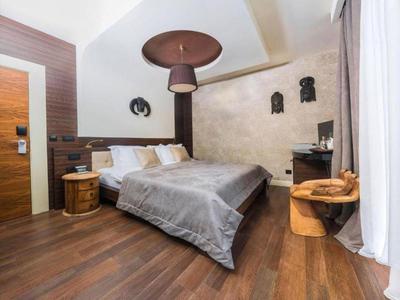 Gemütliches Hotelzimmer mit Doppelbett, Holzboden und modernem, rustikalem Design.