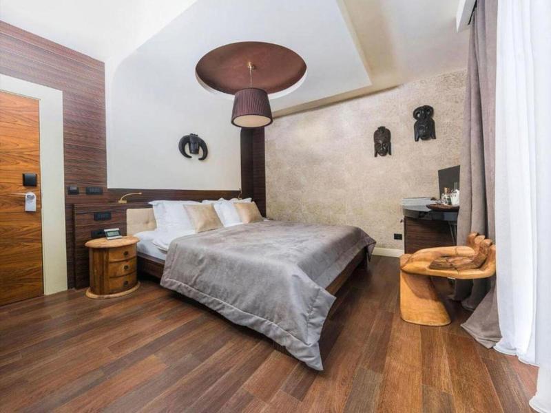 Gemütliches Hotelzimmer mit Doppelbett, Holzboden und modernem, rustikalem Design.