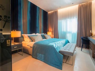 Gemütliches Hotelzimmer mit blauem Bett, Nachttischen und geschriebenem Schreibtisch