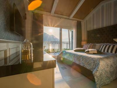 Gemütliches Hotelzimmer mit Blick auf die Berge und Balkon, warme Beleuchtung und modernes Dekor.