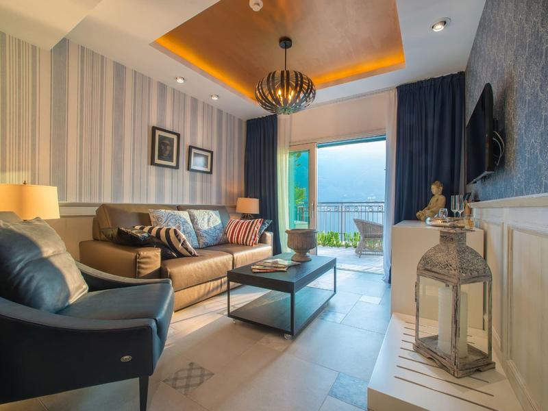 Modern eingerichtetes Wohnzimmer mit Blick auf Meer und Balkon.