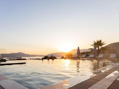 Pool mit Ausblick auf Berge bei Sonnenuntergang in einem Hotelresort