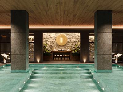 Moderner Innenpool mit stimmungsvoller Beleuchtung und steinverkleideter Wand in einem Luxushotel.