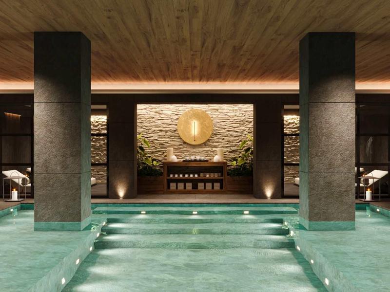Luxusní vnitřní bazén s mramorovými sloupy a teplou dřevěnou výzdobou v elegantní lázeňské oblasti.