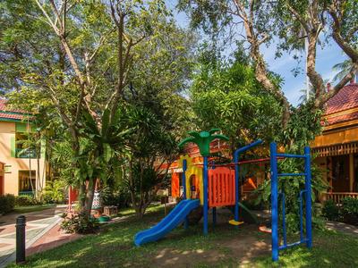 Kinderspielplatz mit Rutsche und Klettergerüst im Garten eines Hotels bei Sonnenschein
