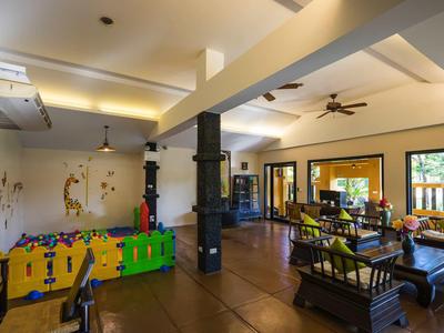 Hell eingerichteter Aufenthaltsraum mit Kinderspielecke und Sitzbereich im Hotel.