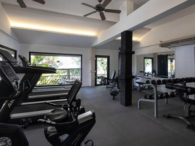 Modern gym with treadmills, dumbbells, and large windows overlooking outdoor area.