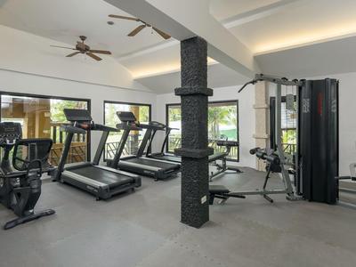 Modern hotel gym with treadmills, exercise machines, and bright walls.