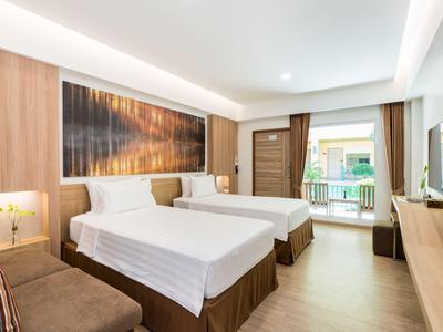 Modern hotel room with two beds, wood accents, and balcony.