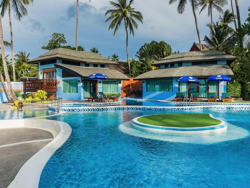 Einladender Pool mit blauem Wasser, Palmen und tropischen Bungalows im Hintergrund unter blauem Himmel.
