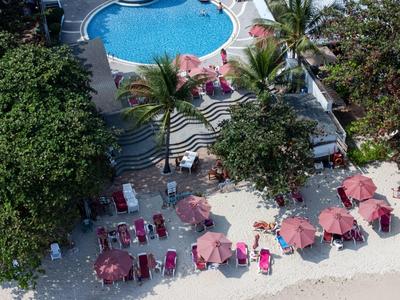 Vista di una piscina dell'hotel con lettini e ombrelloni sulla spiaggia di sabbia.