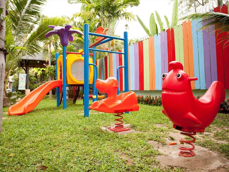 Piscina moderna dell'hotel con lettini e edificio bianco sotto il cielo azzurro.