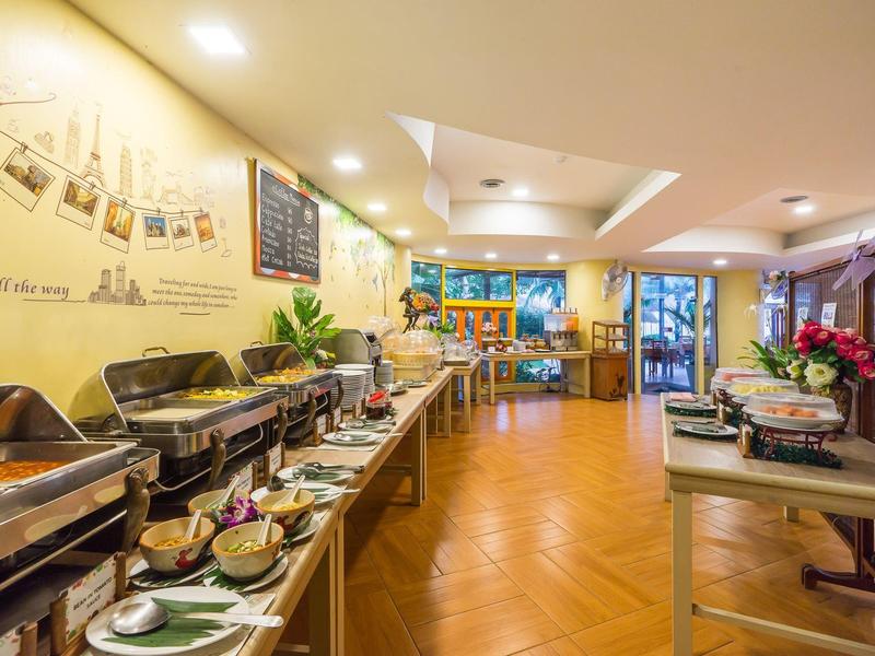 Un buffet di hotel luminoso con piatti caldi e stoviglie su tavoli di legno in una stanza moderna.