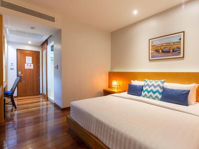 Ein modernes Hotelzimmer mit Doppelbett, Holzfußboden, Schreibtisch und warmem Licht.