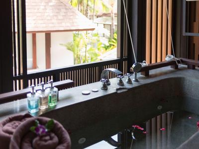 Vasca da bagno di lusso con petali, oli aromatici e asciugamano nel bagno dell'hotel.