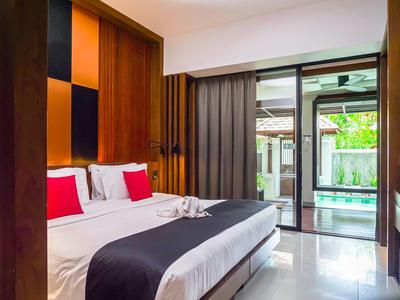 Modern eingerichtetes Hotelzimmer mit Doppelbett, bunten Akzenten und Blick auf Poolbereich.