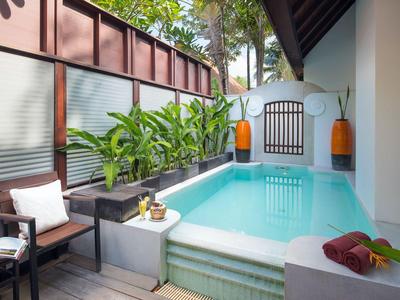 Kleiner privater Poolbereich auf einer Terrasse mit Stühlen und Pflanzen in einem Hotel.