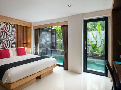 Modernes Hotelzimmer mit großen Betten, Zugang zu privatem Pool und Gartentür.