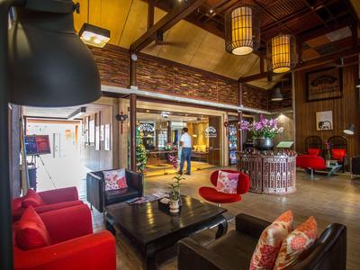 Gemütliche Hotellobby mit roten Sesseln, Holzmöbeln und dekorativem Ambiente.
