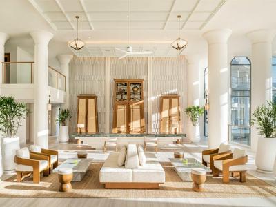 Heller, moderner Lounge-Bereich mit bequemen Sitzgelegenheiten und grünen Pflanzen in einem Hotel.