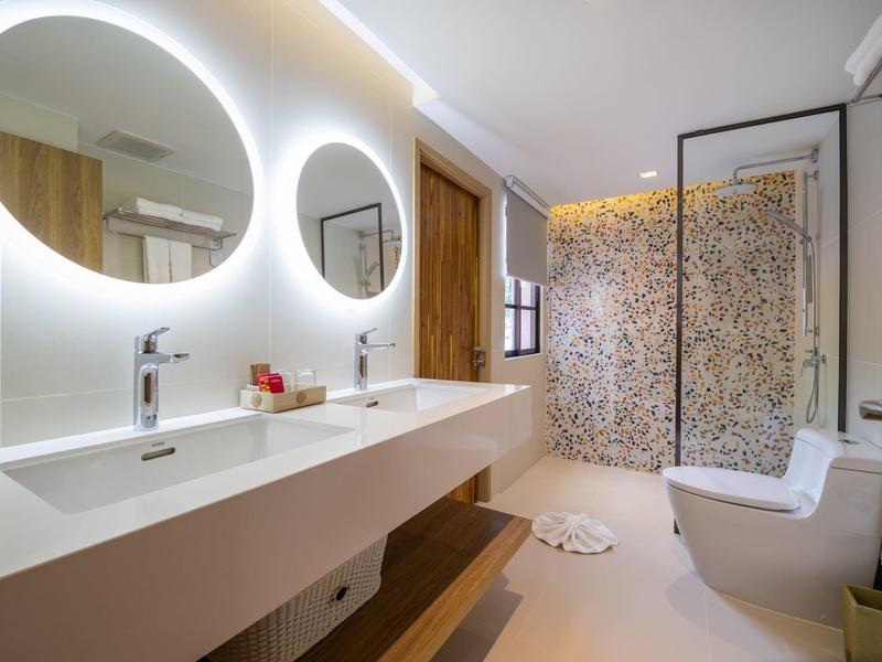 Moderní koupelna s velkým dvojnásobným umyvadlem, osvětlenými zrcadly a sprchovým koutem.