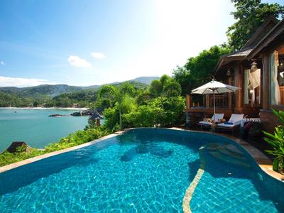 Pool mit Blick auf See und Berge neben einem Holzferienhaus.