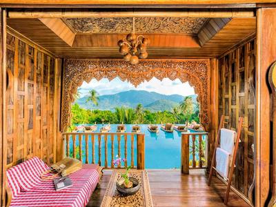Holzterrasse mit Liegestühlen und Bergblick in tropischer Umgebung