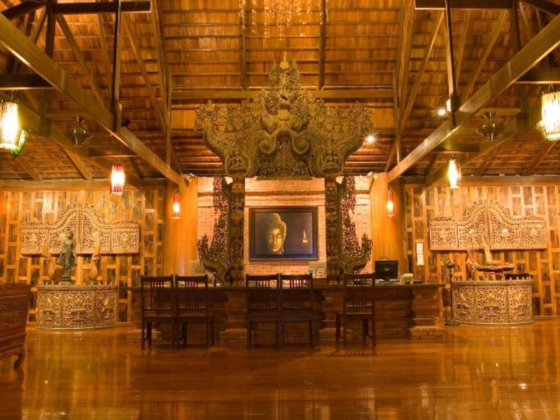 Großer Holzsaal mit hohen Balken, zentralem Altar und warmen, gelben Beleuchtungen.