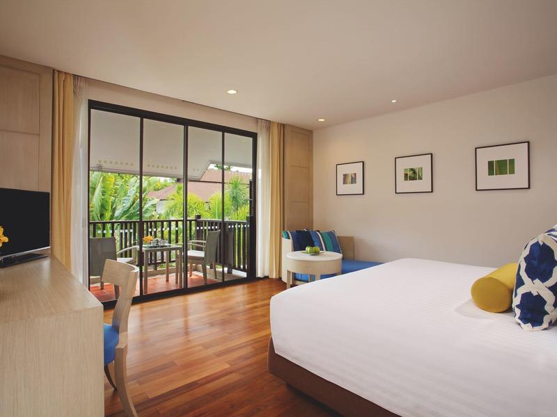 Helles Schlafzimmer mit Holzboden, großem Bett, Balkon und sanfter Beleuchtung.