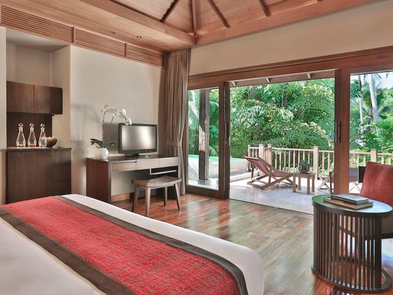 Modernes Schlafzimmer mit Holzboden, großem Bett, TV, Schreibtisch und Terrassentür zum Garten.