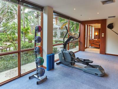 Kleines Fitnessstudio mit Crosstrainer, Hanteln und großen Fenstern zum Garten.