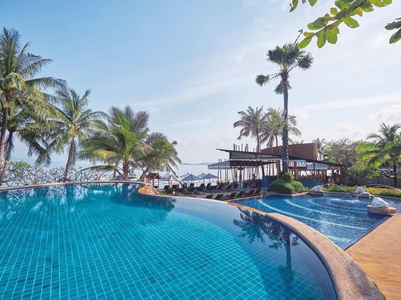 Infinity-Pool mit Palmen und Strandblick an sonnigem Urlaubsort