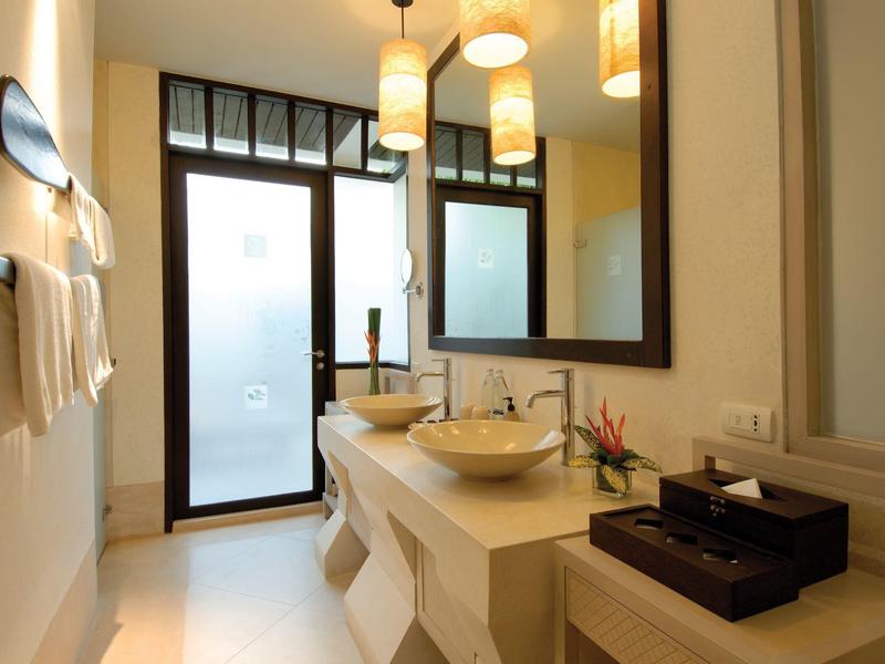 Světelná koupelna s okny od podlahy ke stropu, kulatým umyvadlem a velkými zrcadly.