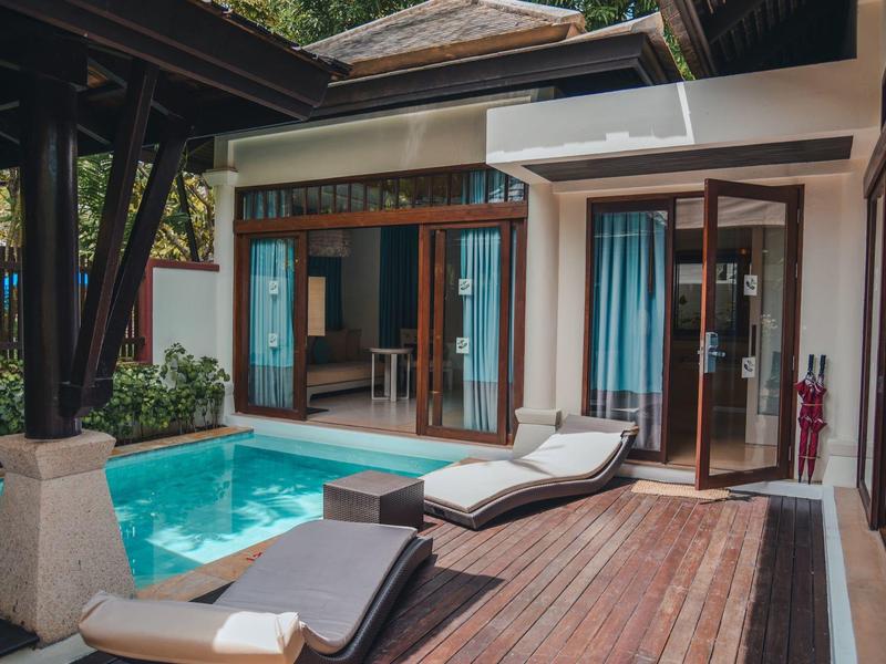 Moderní hotelový pokoj s vlastním bazénem a lehátky na dřevěné terase.