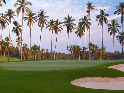 Restauracja na plaży z stołami i krzesłami pod palmami i markizami przy morzu