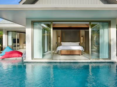 Nowoczesna willa hotelowa z otwartą sypialnią i prywatnym basenem w świetle dziennym.