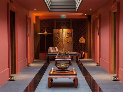 Stylowo urządzony korytarz hotelowy z ciepłym oświetleniem i tradycyjnymi meblami.