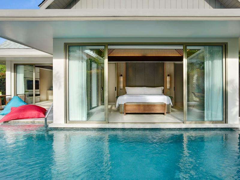 Nowoczesna willa hotelowa z otwartą sypialnią i prywatnym basenem w świetle dziennym.