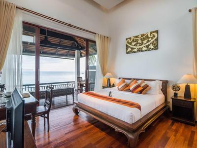 Gemütliches Hotelzimmer mit großem Bett, Meerblick und Balkon mit Sitzgelegenheit.