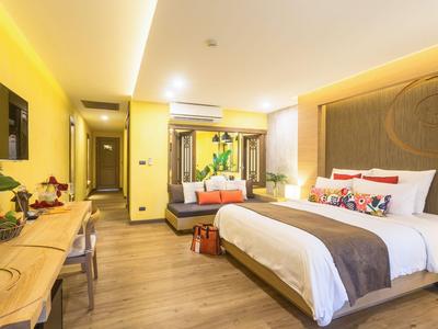 Jasny pokój hotelowy z dużym łóżkiem, biurkiem i częścią wypoczynkową