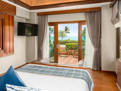 Sypialnia z drewnianą podłogą i widokiem na taras z widokiem na morze