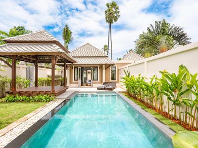 Nowoczesny ogród z basenem, altaną i domem w tle w słoneczny dzień.