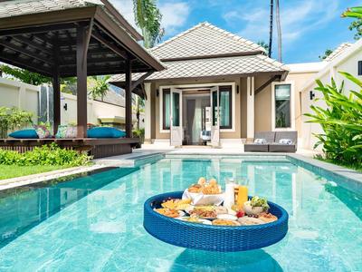 Villa de luxe avec piscine privée et plateau de petit-déjeuner flottant sur l'eau sous un ciel bleu