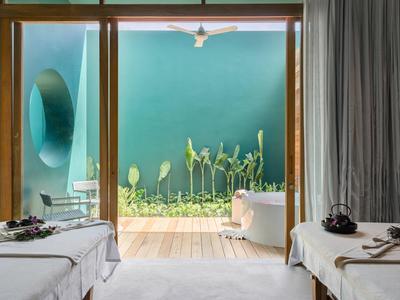 Stanza spa moderna con lettini da massaggio e vista su un giardino verde