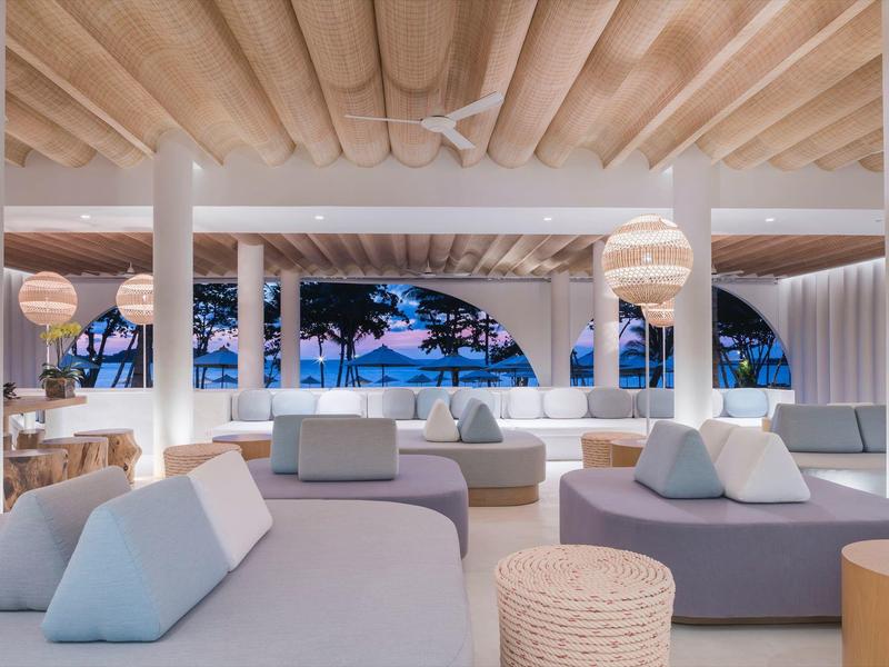 Area lounge moderna con comodi posti a sedere e vista sul tramonto sul mare.